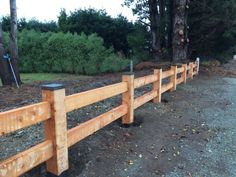 a wooden fence in front of some trees