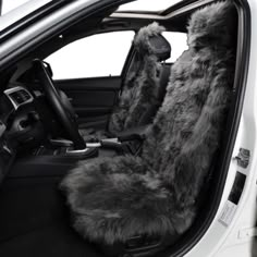 the interior of a white car with furry seats and steering wheel covers in grey fur