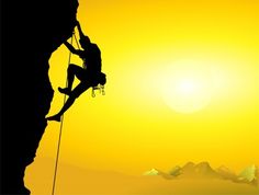 a man climbing up the side of a mountain at sunset