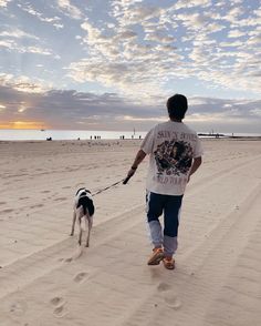 a man walking his dog on the beach