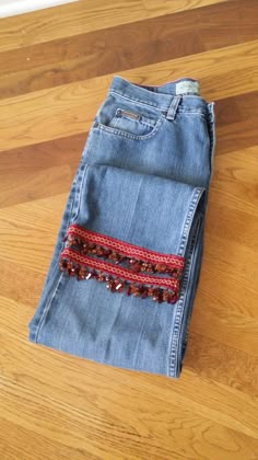 a pair of jeans sitting on top of a wooden floor