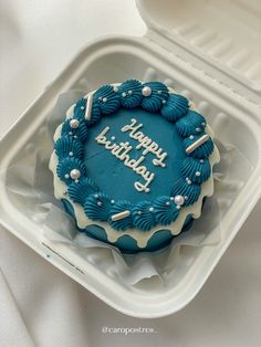 a blue birthday cake in a plastic container