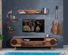 a living room with an entertainment center and guitars on the wall