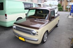 a tan and brown truck parked next to a green bus