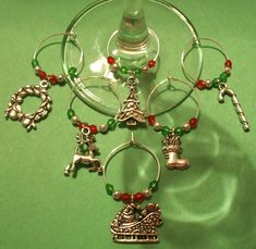 a wine glass with some charms attached to it on a green table top next to a wine glass holder