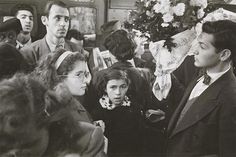 an old black and white photo of people on a crowded subway train platform in the early 20th century