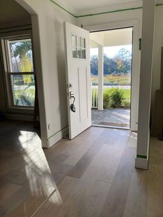 an empty room with white doors and hard wood flooring on the side of it