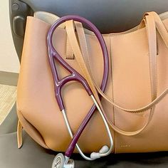 a purse with a stethoscope in it sitting on top of a chair