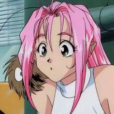 a girl with pink hair and big eyes looks at the camera while holding her hand on her shoulder