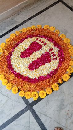 a circular flower arrangement with the letter e on it's side and yellow flowers in the middle