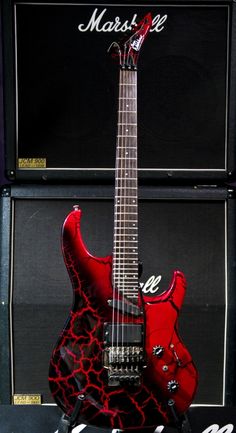 a red guitar sitting on top of a table