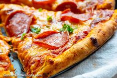 a pizza with pepperoni and parsley on it is cut into four slices, sitting on a paper towel