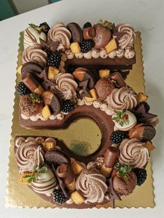 a cake with chocolate frosting and fruit toppings in the shape of a heart