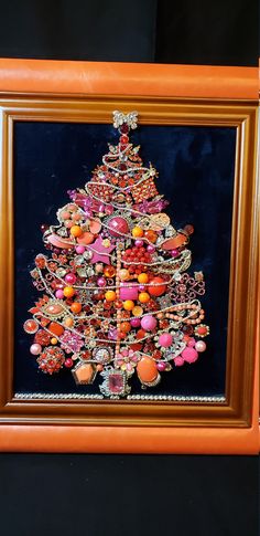 a christmas tree made out of buttons and other items in a wooden frame on a black background