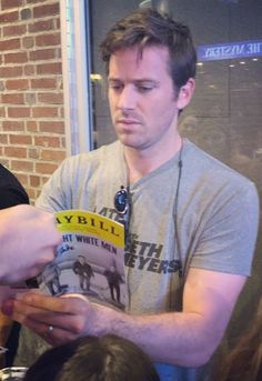 a man reading a book in front of a group of people