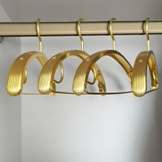 gold clothes hangers are hanging on a rail