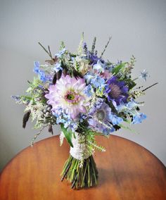 a bouquet of flowers sitting on top of a wooden table