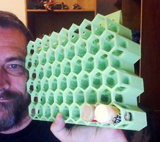 a man holding an egg crate in front of his face