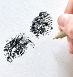 someone is drawing an eye on paper with a marker