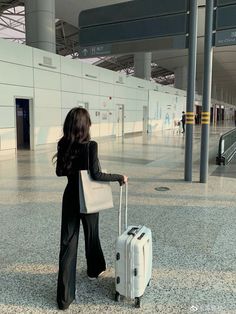 a woman with a suitcase in an airport