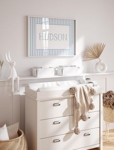 a baby's room with white furniture and blue striped wall art above the changing table