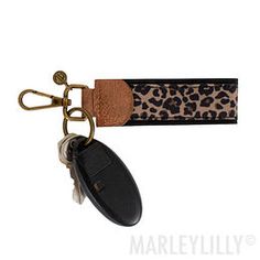 a leopard print keychain with a black car key fobring attached to it