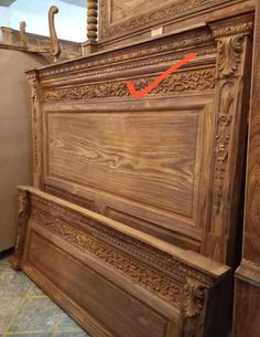 a wooden bed frame with an arrow pointing to the headboard