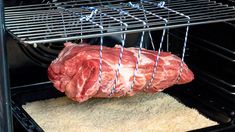 raw meat being cooked in an oven with the door open to show it's inside