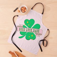 a white apron with a green clover on the front and good luck written across it