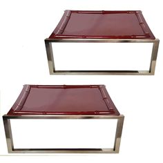 a pair of red glass and chrome coffee tables with matching trays on each side