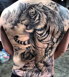 the back of a man with a tiger tattoo on his upper and lower half body