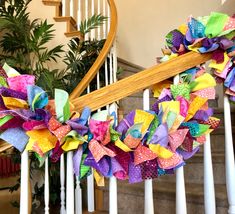 the colorful wreath is hanging on the banister