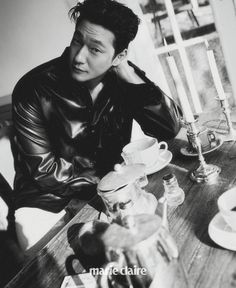 a black and white photo of a man sitting at a table