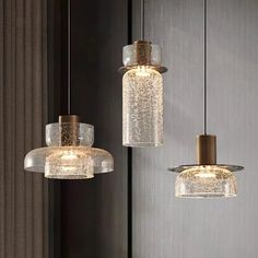 three glass pendant lights hanging from the ceiling