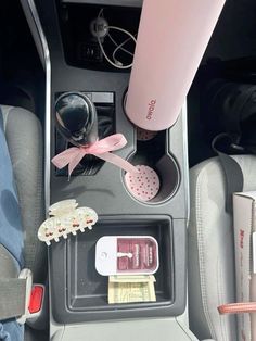 the interior of a car with various items in it and a pink water bottle on top