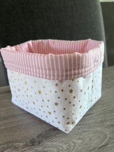 a close up of a cloth basket on a table with a chair in the background