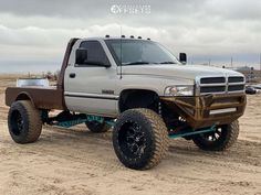 a white truck parked on top of a dirt field