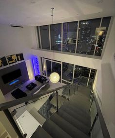 the stairs lead up to an open floor plan with glass railings and modern lighting