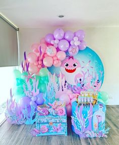 an under the sea themed birthday party with balloons, decorations and other items on wooden flooring