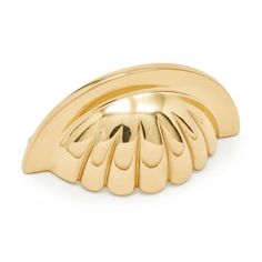 a gold scallop shaped object on a white background