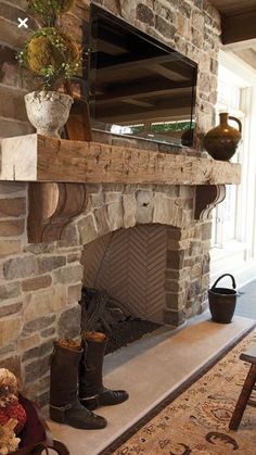 a living room with a stone fireplace and tv