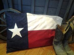 a pair of cowboy boots sitting next to a texas flag pillow