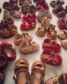 many pairs of baby shoes are laid out on the floor