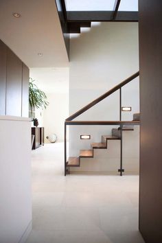 a staircase leading up to the top floor in a modern house with white walls and floors