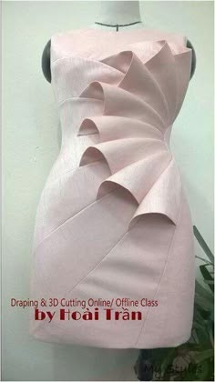 a dress made out of pink paper on a mannequin