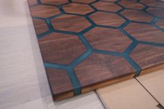 a wooden cutting board sitting on top of a kitchen floor next to a countertop