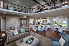 a living room filled with lots of furniture and a large open floor plan above it