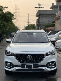 a white car is parked on the side of the road in front of other cars