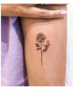 a woman's thigh with a rose tattoo on it