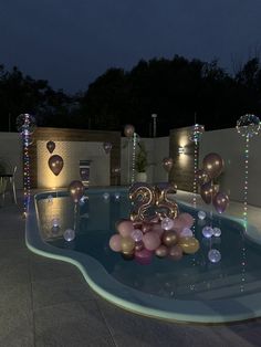 an outdoor pool with balloons and lights on it